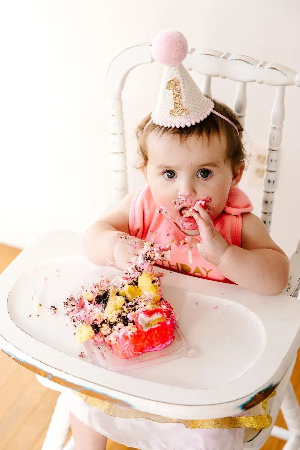 One-year-old eating birthday cake with her hands in a studio session