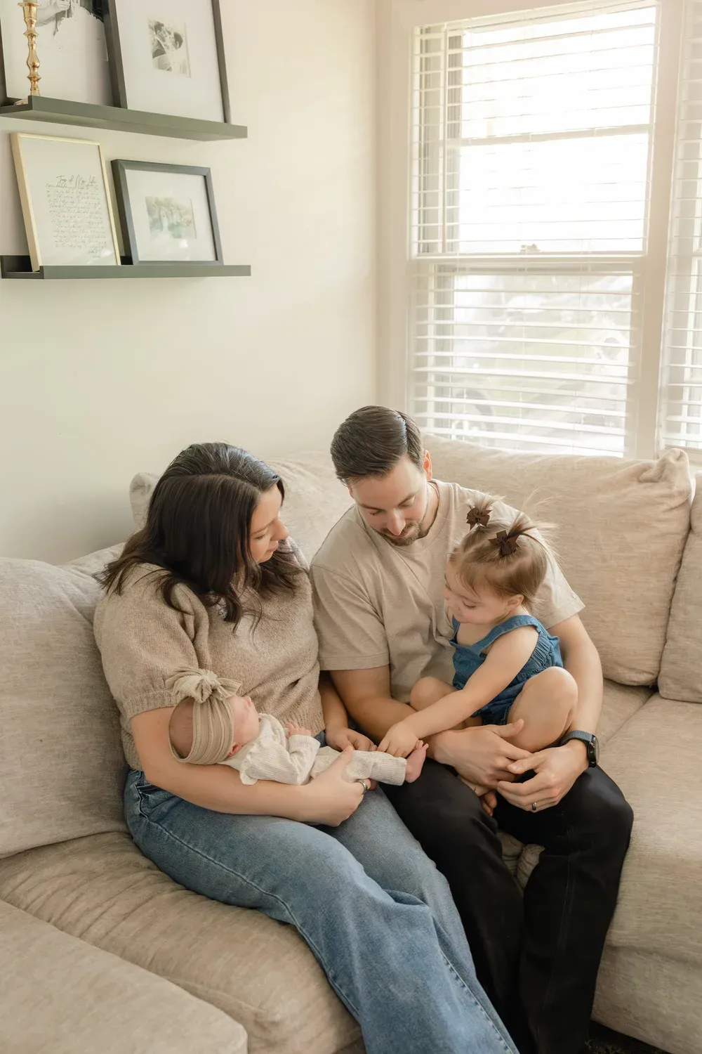 Family of four laughing together on the couch at home